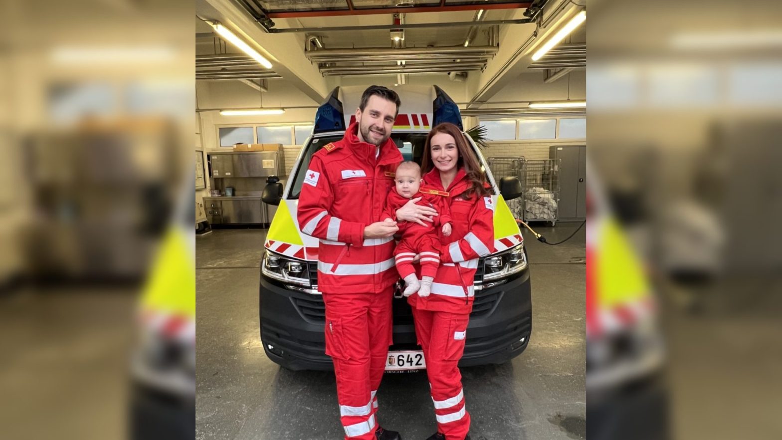 Thomas Haag und Lisa Rader mit ihrem gemeinsam Baby in der Rotkreuz-Uniform vor einem Rettungswagen