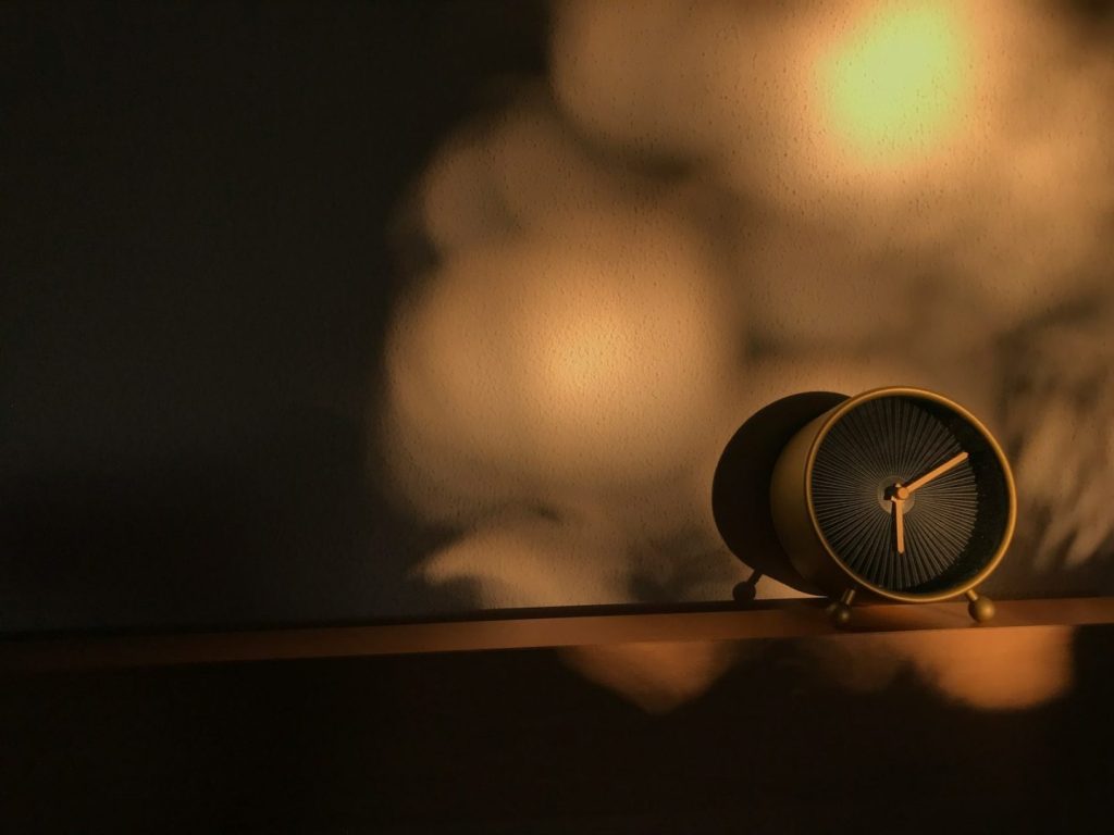 a clock sitting on top of a wooden shelf