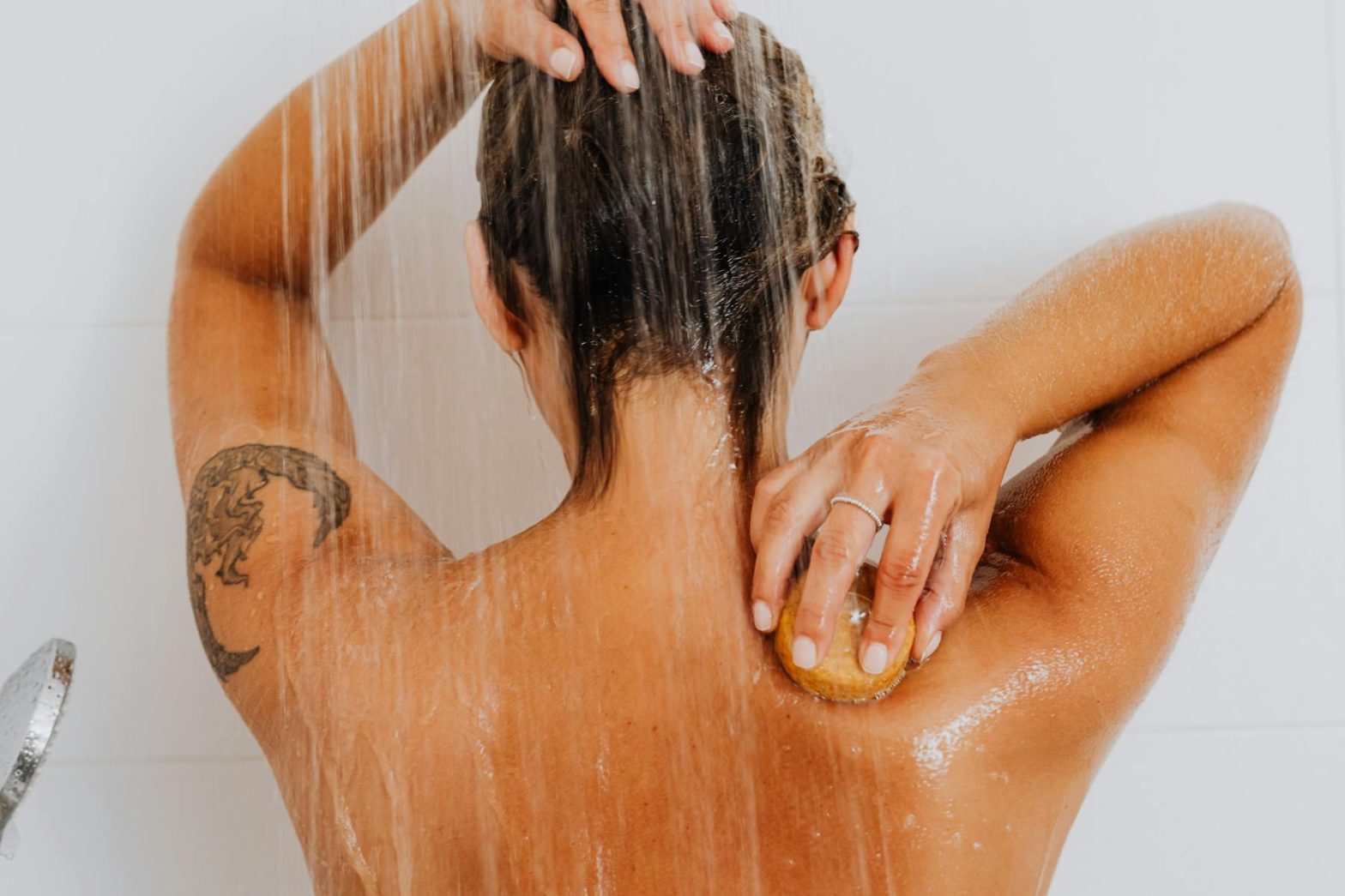 Woman Under Shower Washing Her Back