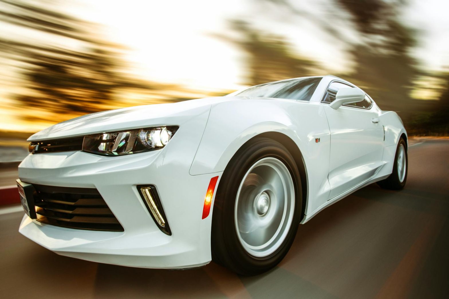 A white sportscar in motion showcasing speed and style on an open road.